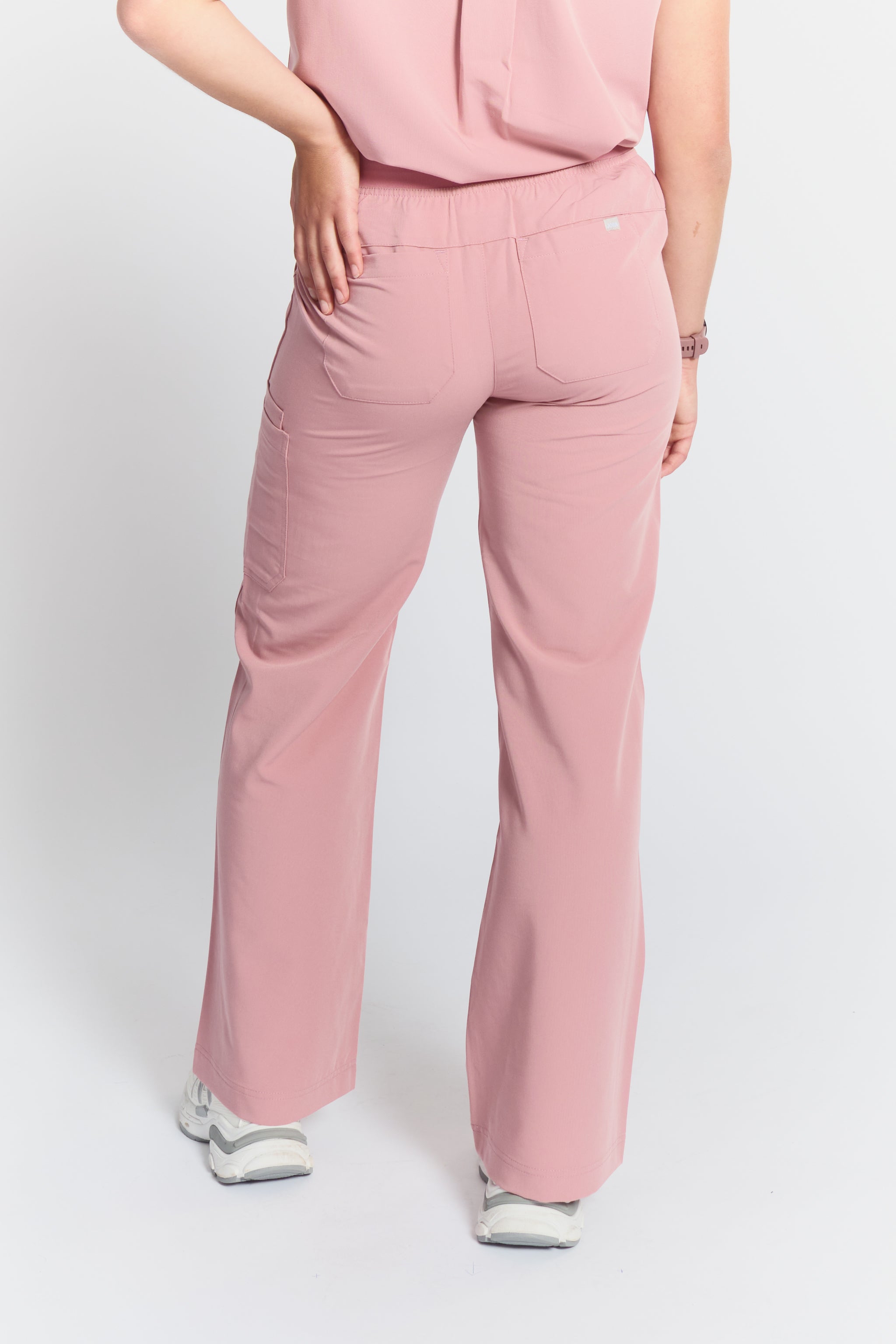 Person wearing pink scrubs on a white background