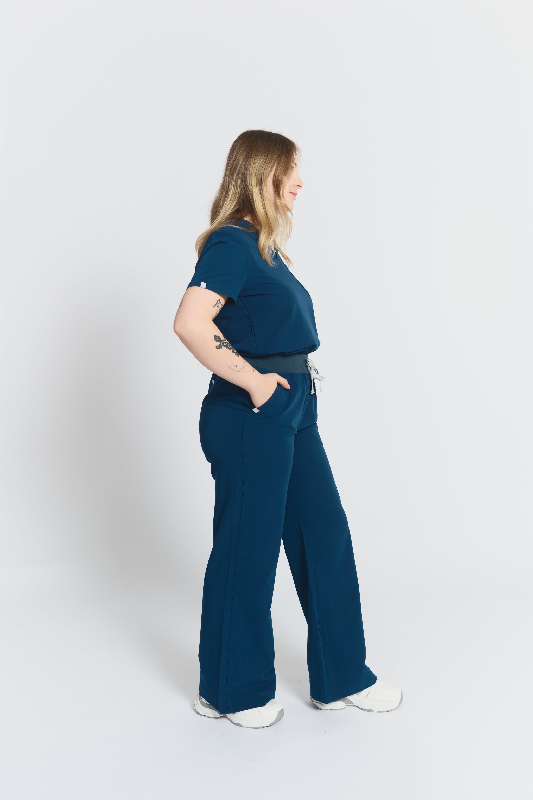 Woman wearing a blue scrubs outfit on a white background